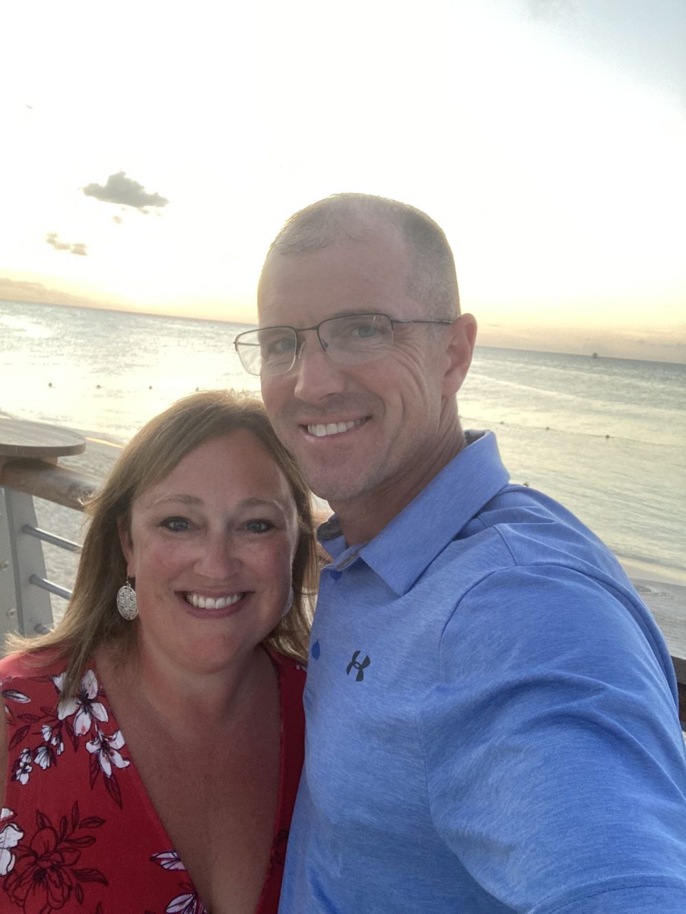 ’Chelle and her husband smiling together by the water at sunset