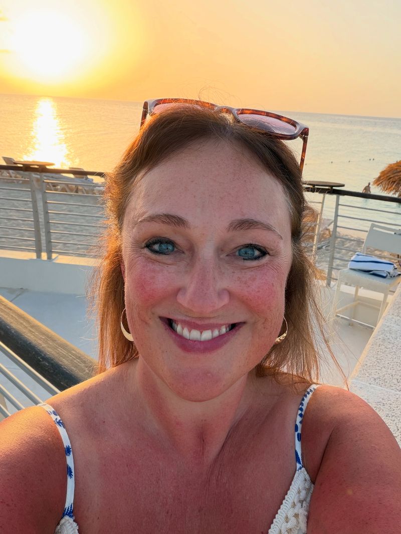 ’Chelle smiling on a cruise ship deck at sunset